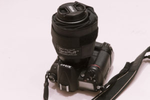 LensMuff with 2 hand warmers inside wrapped around a camera lens.